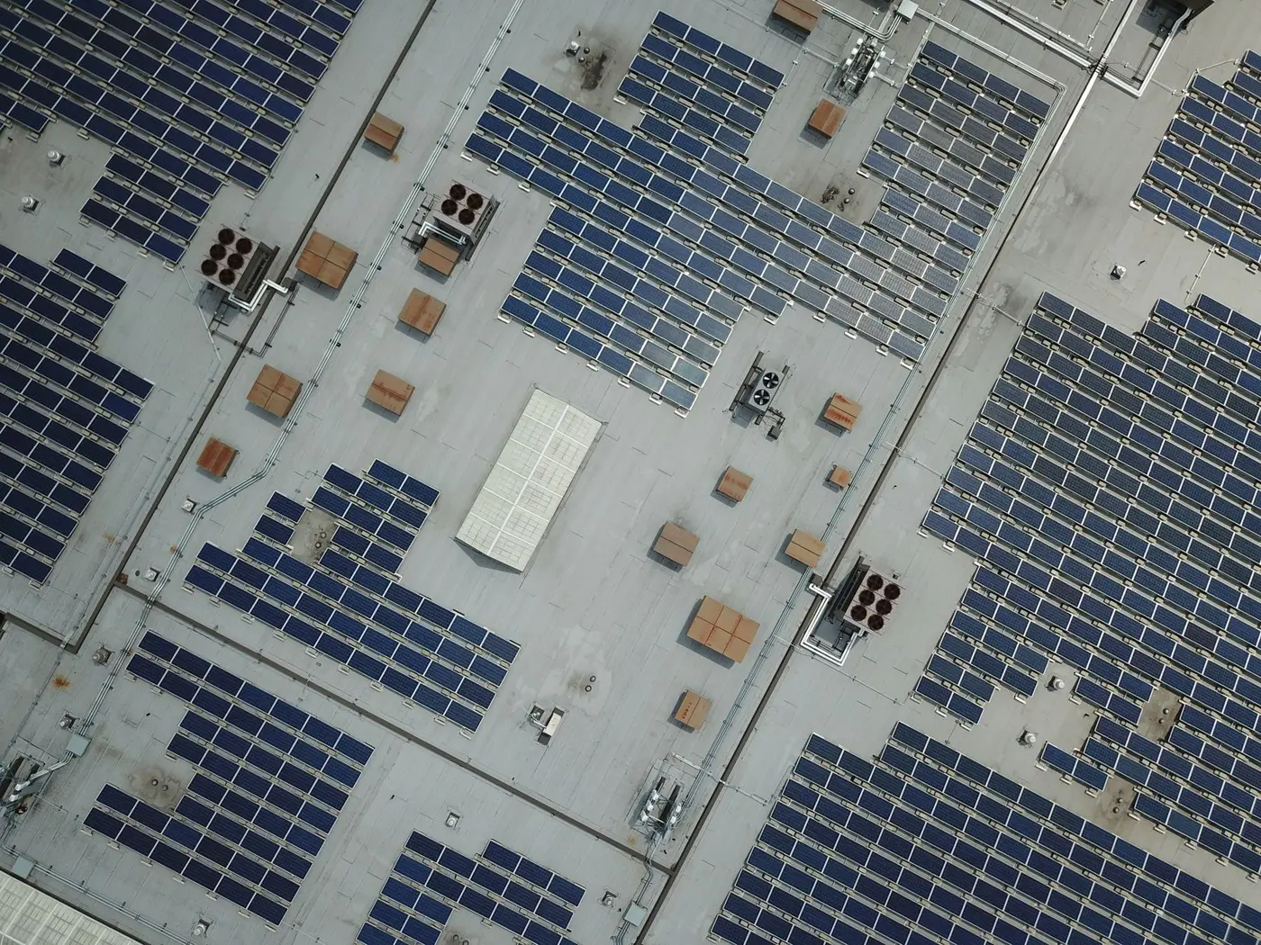 Aerial view of a large rooftop solar array across a commercial building roof