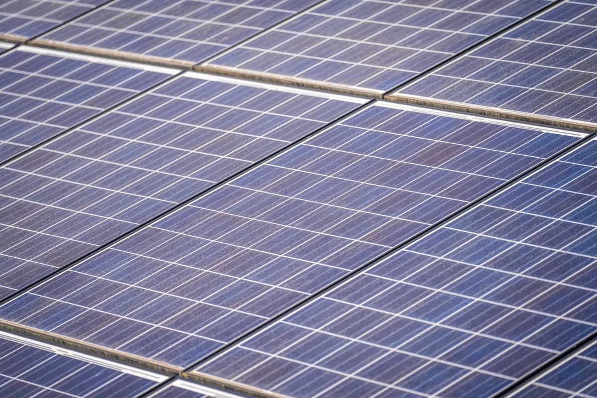 Close-up of photovoltaic panel glass showing a dulled film across the cell surface