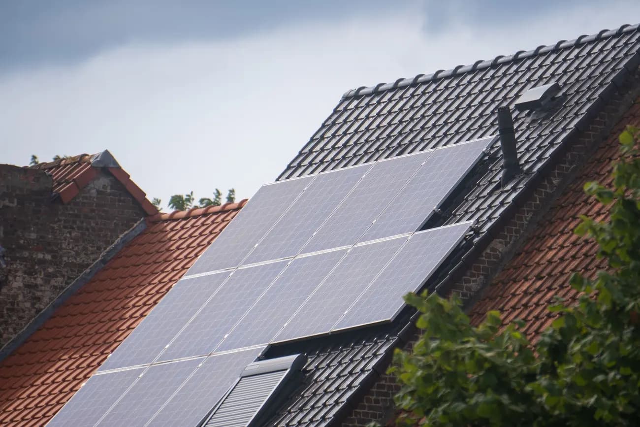 Solar panels on a residential roof under a grey overcast sky